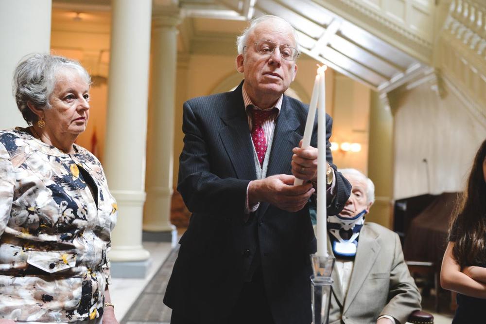 At 2013 Days of Remembrance ceremony, Steven Low lights a candle.