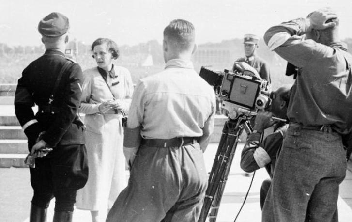 Nuremberg, Germany - Sep. 9, 1934: Leni Riefenstahl (center) with Heinrich Himmler (left), Reich Leader of the SS, while filming scenes for "Triumph of the Will" at Luitpold Arena. Photo: German Federal Archives. 