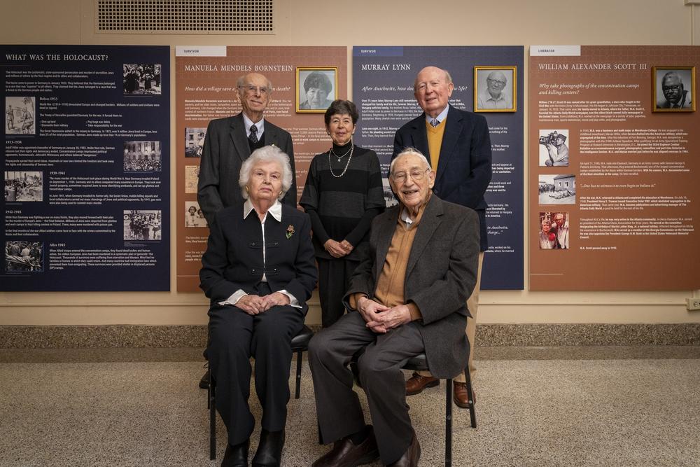 Survivors in front of exhibit panels